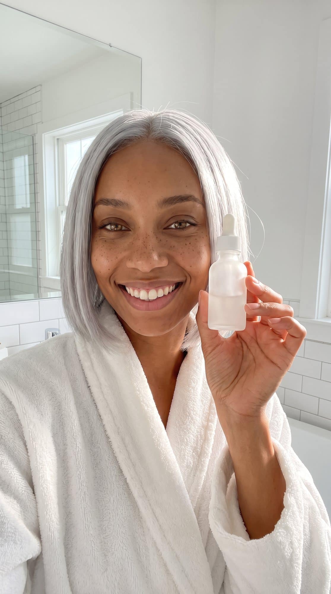 Nova holding up a skincare bottle in a bright bathroom
